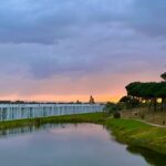 Alcino Soutinho's Soutinho 14 Villas at Bom Sucesso Resort in Obidos, showcasing modern architecture with a reflective watercourse and serene wetland setting at dusk.
