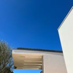 Alcino Soutinho's design of the Soutinho 14 Villas at Bom Sucesso Resort in Obidos showcasing modern architecture with composite material walls, highlighted by sunlight and shade during daytime.