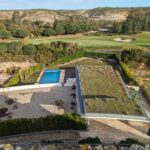 Alcino Soutinho's design of the Soutinho 4 Grandes Villas at Bom Sucesso Resort in Obidos features a modern landscape with a swimming pool and expansive estate visible from an aerial perspective.