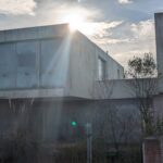 Alcino Soutinho's design of the Soutinho Conjunto de 28 Habitações em Banda at Bom Sucesso Resort, Obidos, showcasing a modern concrete structure with composite materials and ample daylighting during the daytime.