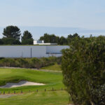 Álvaro Siza Vieira's O Espaço de Siza no Bom Sucesso – Nave Lagoa at Bom Sucesso Resort, Obidos, showcasing a modern design with a sleek, white exterior and expansive glass panels.