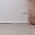 Álvaro Siza Vieira's O Espaço de Siza no Bom Sucesso – Nave Lagoa at Bom Sucesso Resort, Obidos, showcasing a modern interior design with sleek furniture, a glass kitchen and dining room table, and elegant flooring.