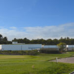 Álvaro Siza Vieira's O Espaço de Siza no Bom Sucesso – Nave Lagoa at Bom Sucesso Resort, Obidos, showcasing a triangular design with wooden flooring, composite material stairs, and a plaster ceiling.