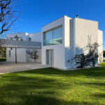 David Chipperfield's Chipperfield 4 Villas no Bom Sucesso showcasing a modern residential design with a landscaped garden, expansive lawn, and elegant villa structures within the Bom Sucesso Resort, Obidos.