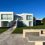 David Chipperfield's Chipperfield 4 Villas no Bom Sucesso showcasing a modern design with concrete and composite materials, featuring shaded courtyards, balconies, and strategic daylighting within the Bom Sucesso Resort, Obidos.